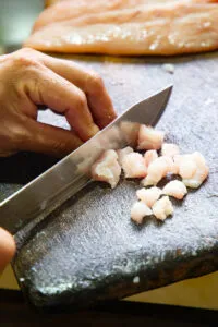Zubereitungsschritt: Weißfisch (Corvina) wird für das Ceviche in Würfel geschnitten