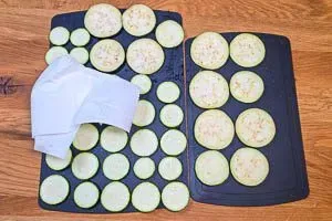 Zucchini und Aubergine mit Küchenpapier trockentupfen
