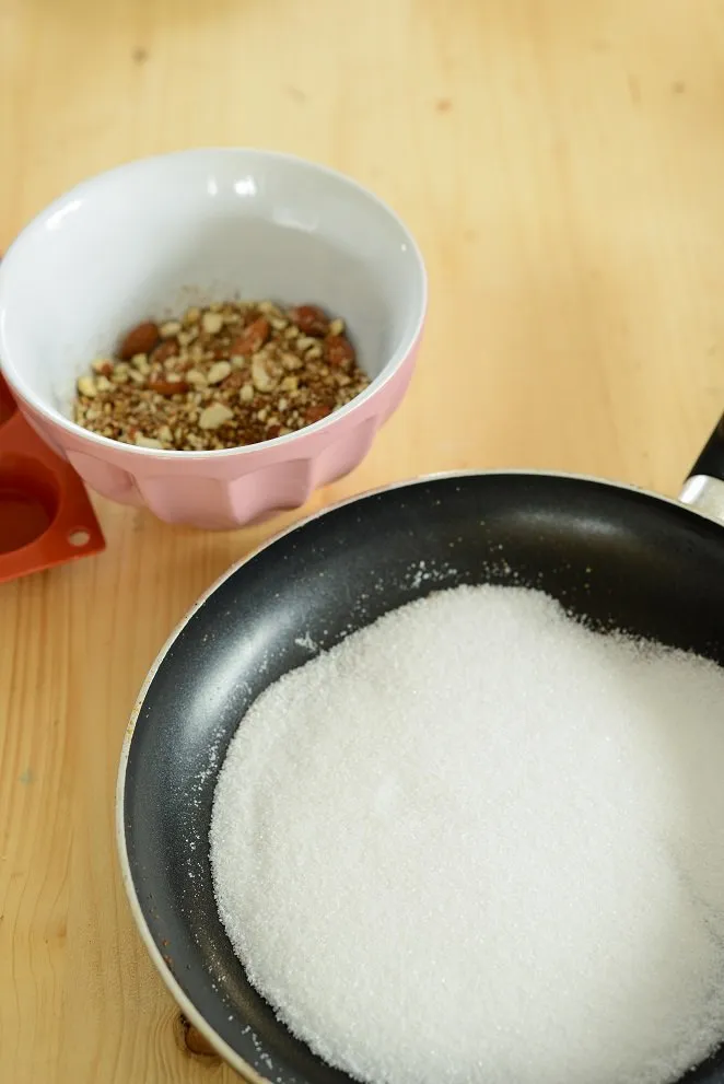 Zucker schmilzt langsam zu Karamell in der Pfanne für die Florentiner Masse.