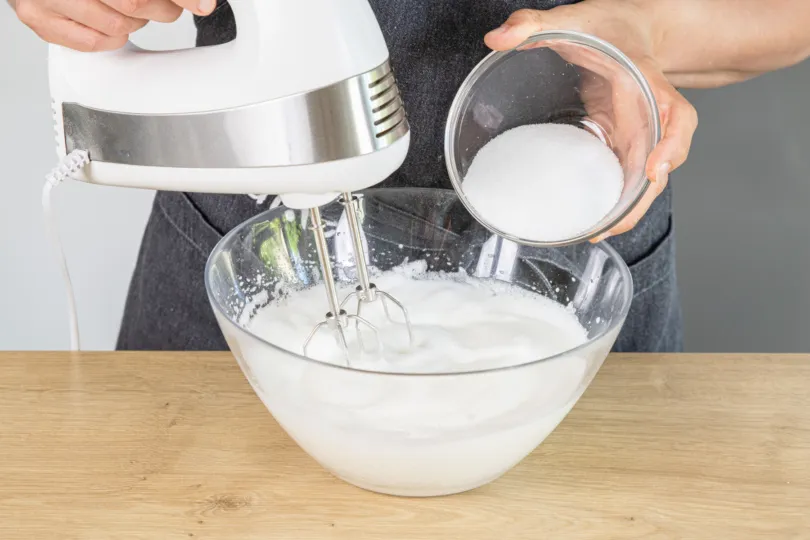 Zucker wird langsam in den Eischnee gegeben