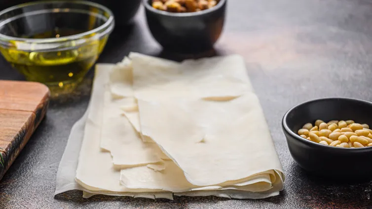 Zusammengefalteter, selbstgemachter Yufka-Teig auf einer Arbeitsfläche.