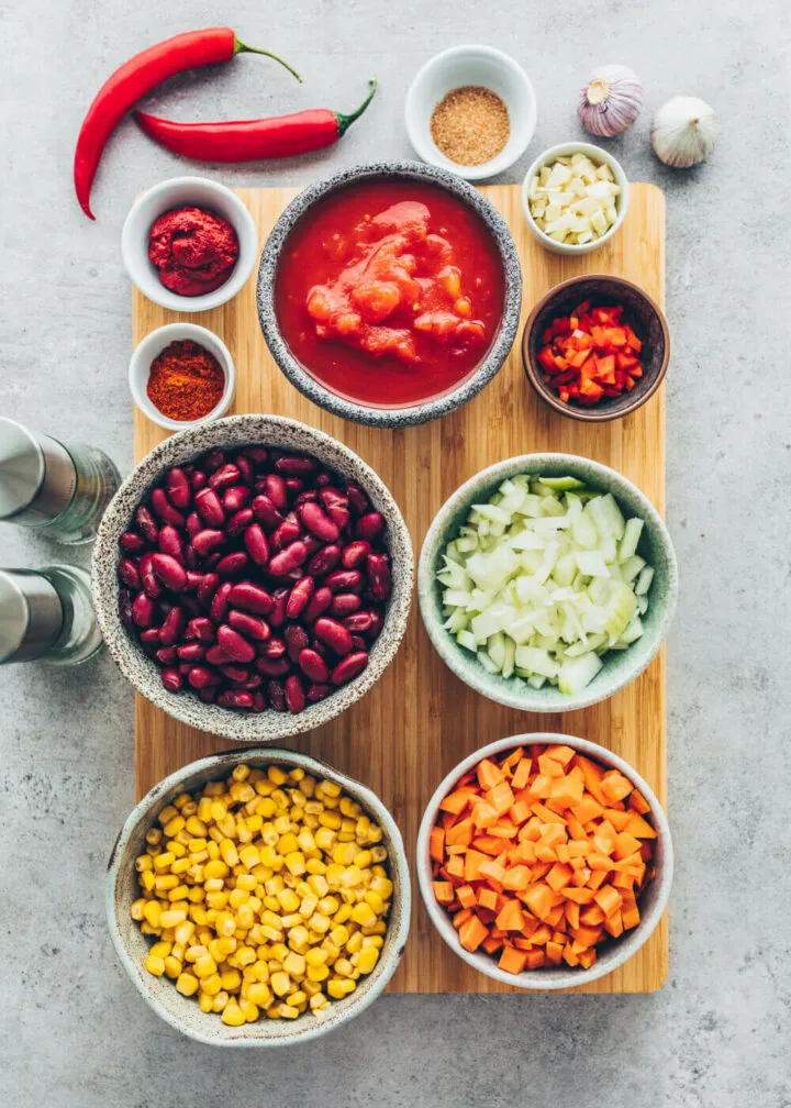 Zutaten für Chili sin Carne: Kidneybohnen, Mais, Tomaten, Karotten, Zwiebeln, Knoblauch, Gewürze