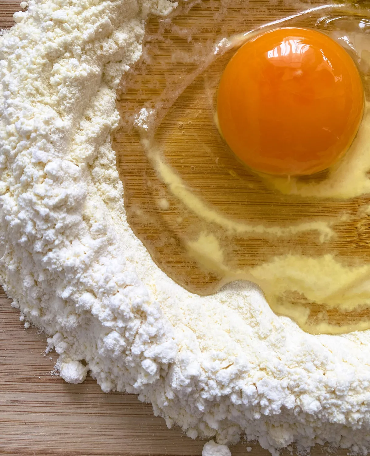 Zutaten für den Nudelteig: Mehlhaufen mit Eiern und Olivenöl in der Mitte