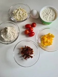 Zutaten für einfache körniger Frischkäse Rezepte: Hüttenkäse, Gemüse und Gewürze bereit zur Zubereitung.