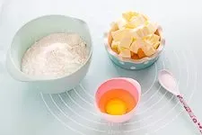 Zutaten für hausgemachten Quiche Teig: Mehl, Butter, Ei, Salz.