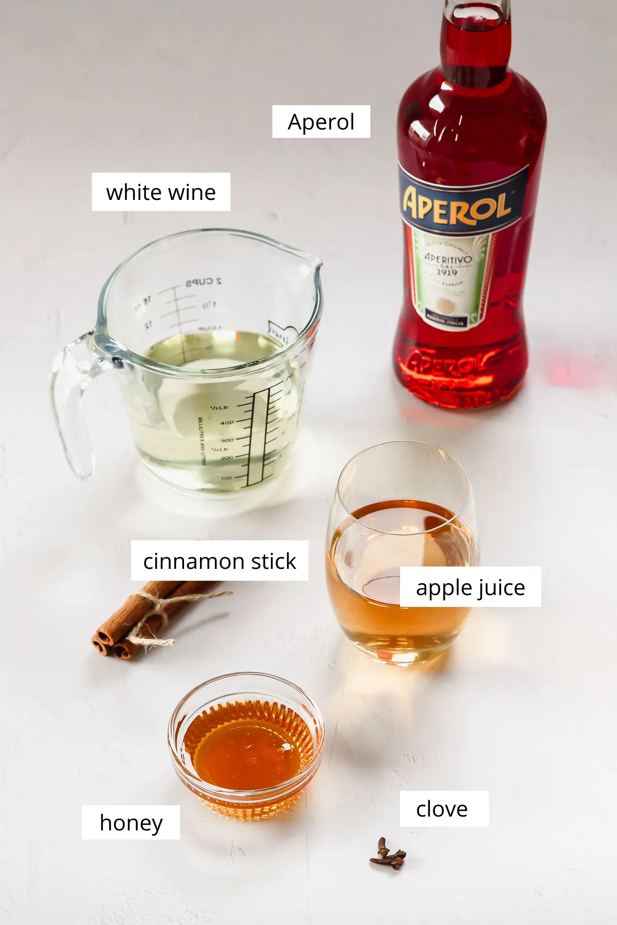 Zutaten für heißen Aperol auf grau-weißem Hintergrund.