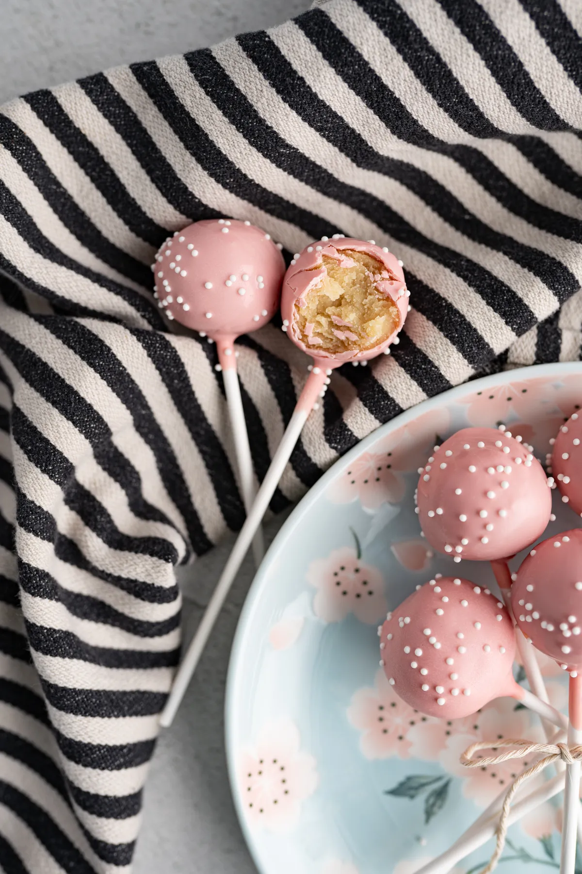 Zwei Cake Pops (Starbucks Duplikat) auf einem gestreiften Tuch.