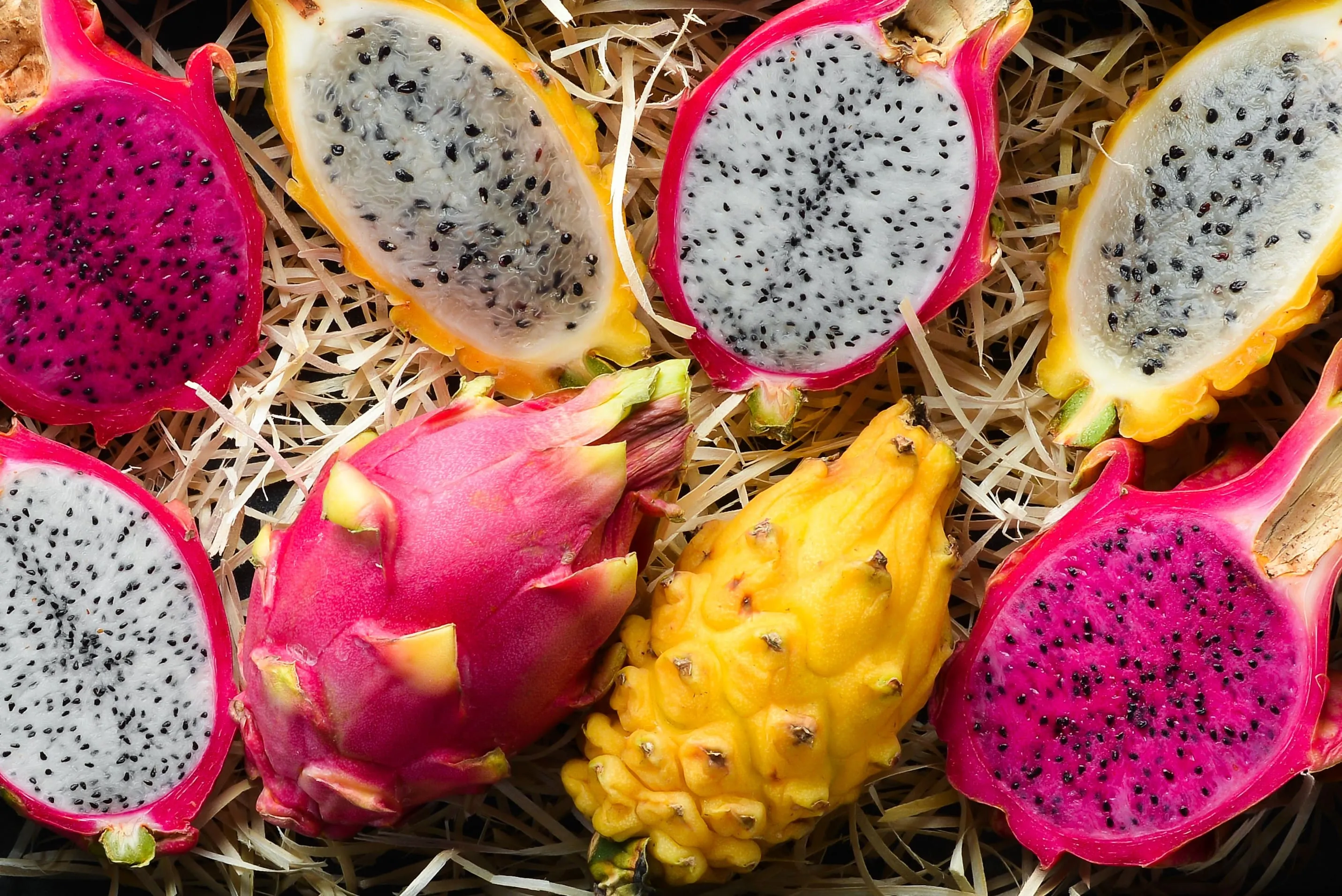 Zwei Gläser Drachenfruchtsaft, eines aus pinker und eines aus gelber Drachenfrucht, ansprechend angerichtet, die die Vielfalt des Drachenfruchtsaftes betonen.