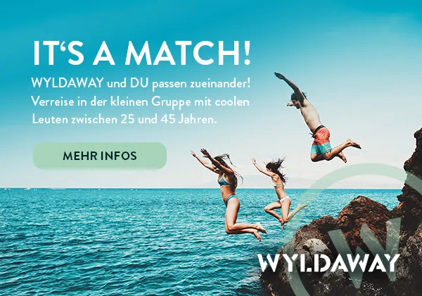 Zwei Personen, die sich bei einer Wanderung im Grünen unterhalten, symbolisieren die Suche nach einem Reisepartner