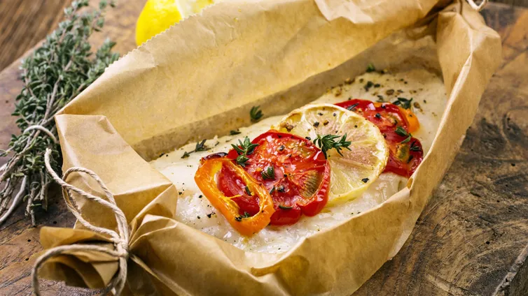 Zwei Portionen Kabeljau in Backpapier mit Fenchel und Gemüse, frisch aus dem Ofen