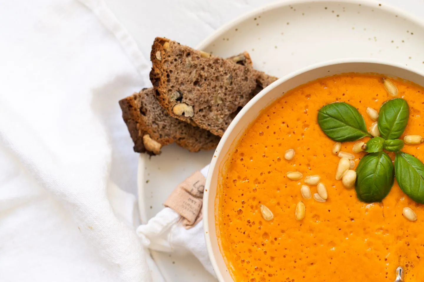 Zwei Schalen mit cremiger Tomatencremesuppe und Basilikum garniert