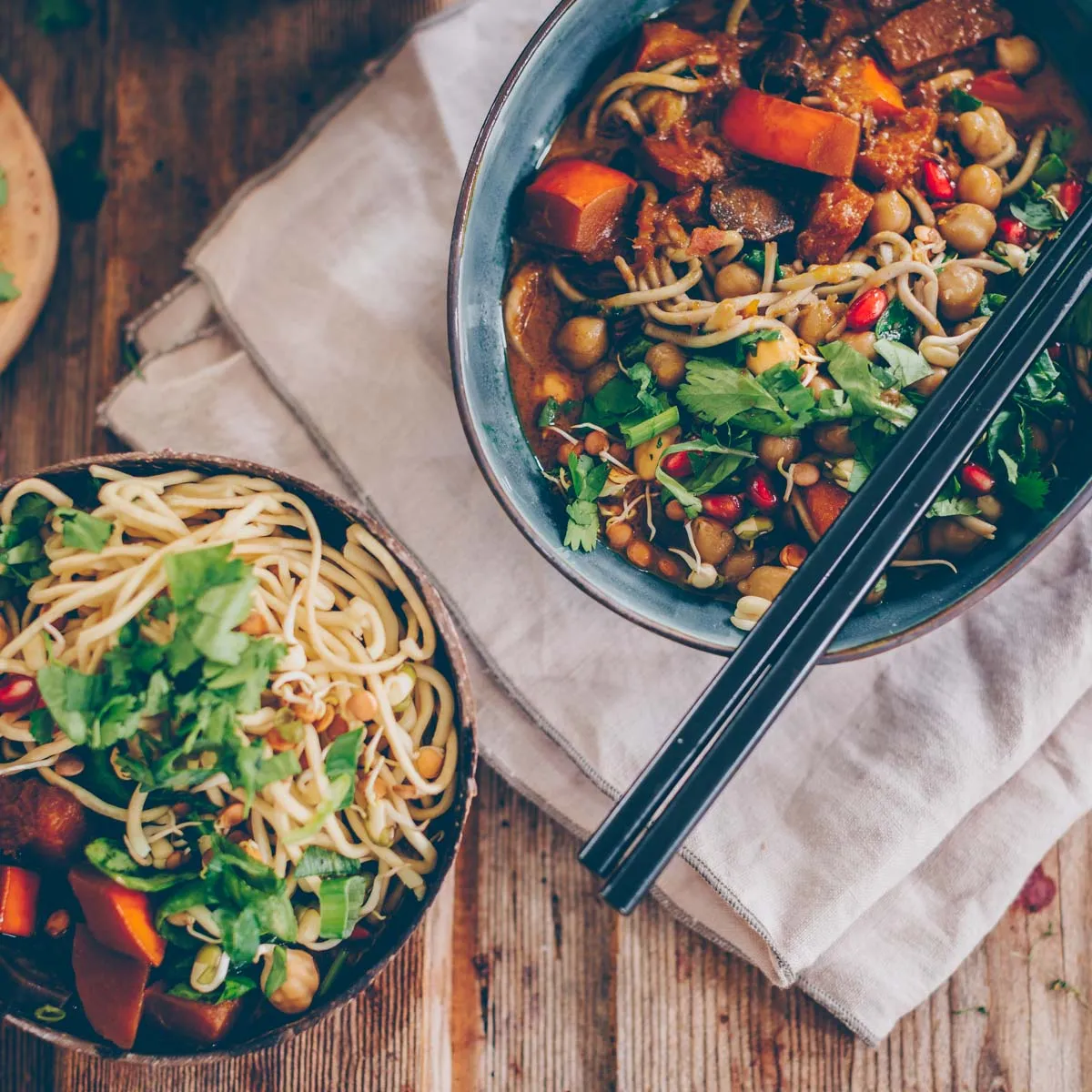 Zwei Schalen mit Kürbis-Curry und Mie-Nudeln, die ein gemeinsames Essen andeuten.