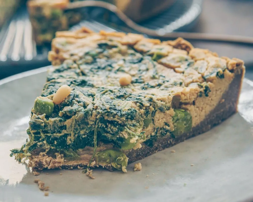 Zwei Stücke vegane Spinat Quiche, appetitlich angerichtet