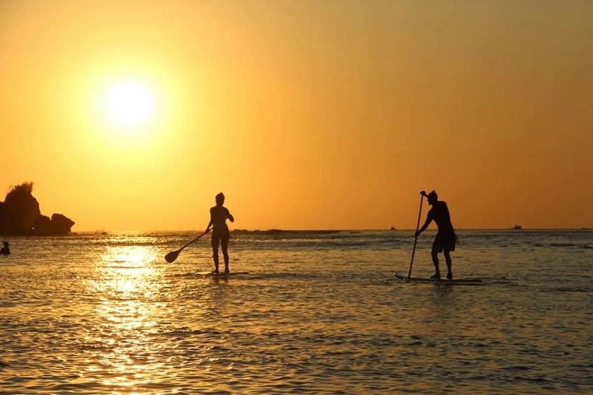 Zwei SUP-Surfer erkunden die kristallklaren Gewässer um Nusa Lembongan, Indonesien, eine idyllische Insel für einen Mai-Urlaub nach der Regenzeit.
