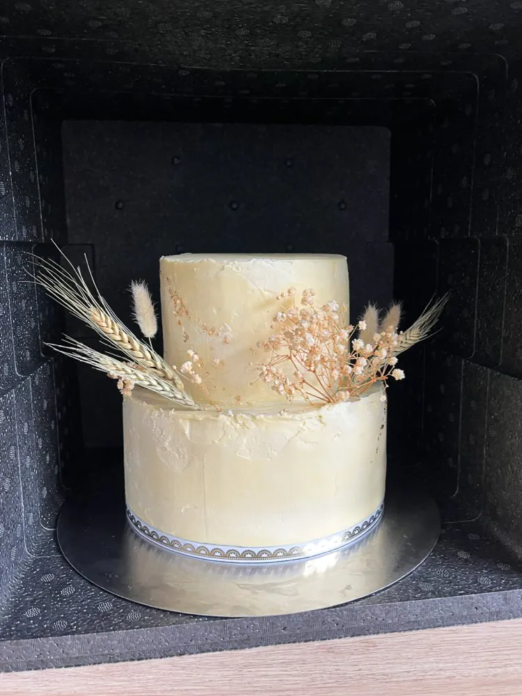 Zweistöckige Hochzeitstorte in einer großen Thermobox für den sicheren Transport