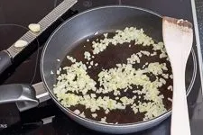 Zwiebeln und Knoblauch andünsten für die herzhafte Hackfleischfüllung der Zucchini