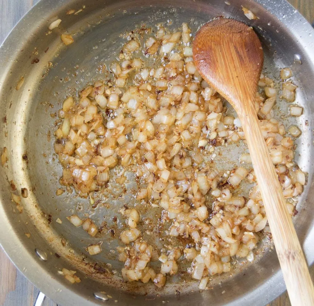 Zwiebeln und Knoblauch in der Pfanne andünsten für die Stroganoff-Soße