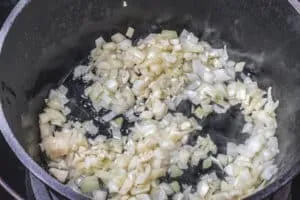 Zwiebeln und Knoblauch werden für das Grünkohlrezept in Schmalz angedünstet.