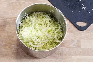 Zwiebeln und Kohl durchkneten.