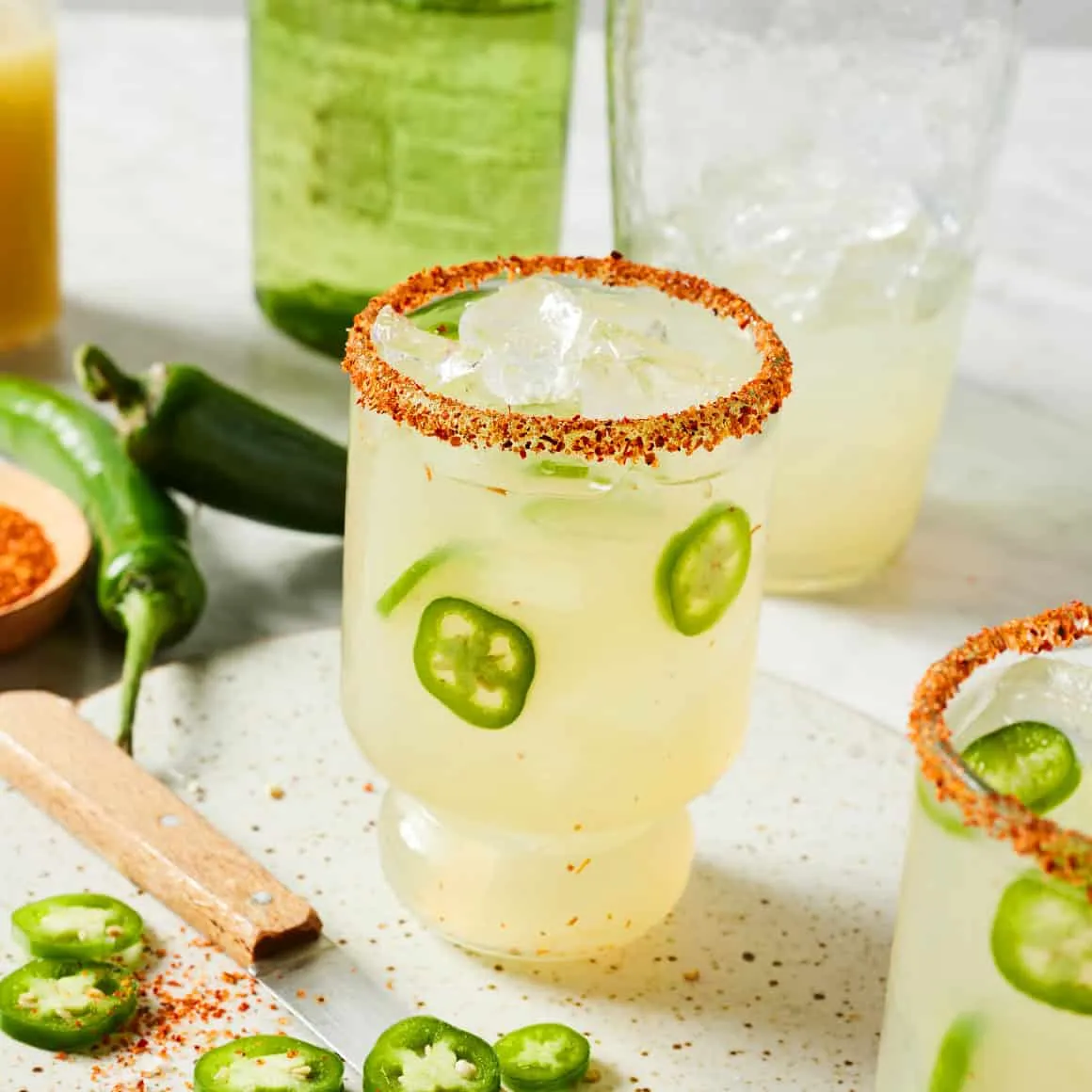 A refreshing spicy margarita in a glass, garnished with jalapeño slices.