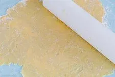 Ausrollen des Plätzchenteigs mit einem Nudelholz