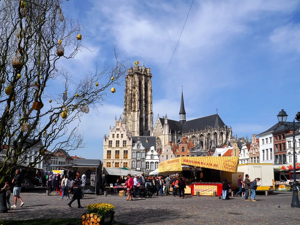 Belebter Markt in Mechelen, Belgien, mit historischen Gebäuden und festlicher Osterdekoration
