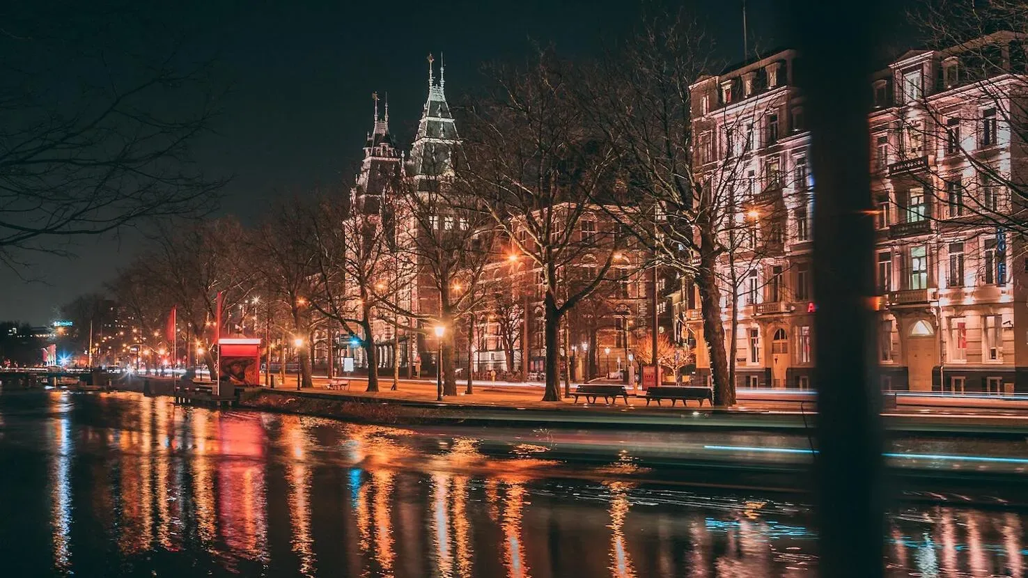 Beleuchtete Grachten in Amsterdam bei Nacht im Winter