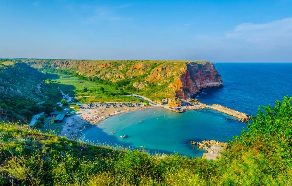 Blick auf den Sonnenstrand in Bulgarien mit bunten Sonnenschirmen und türkisfarbenem Meer.