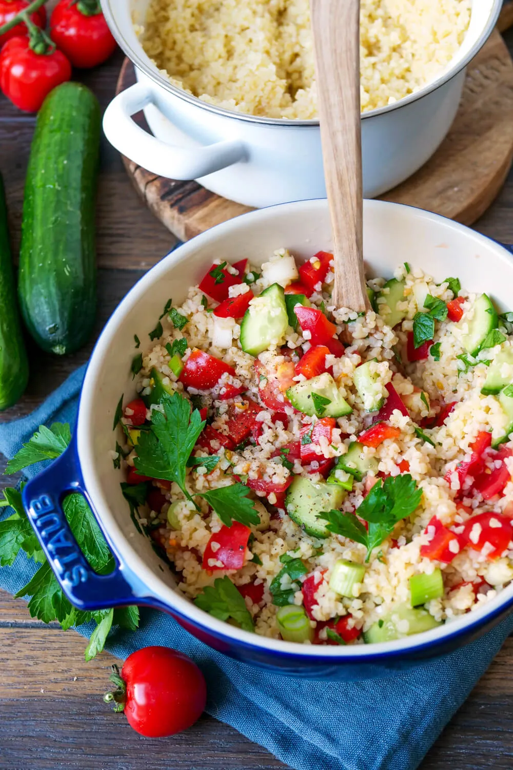 Bulgur gekocht in einem Topf mit Gurke, Paprika und Kräutern.