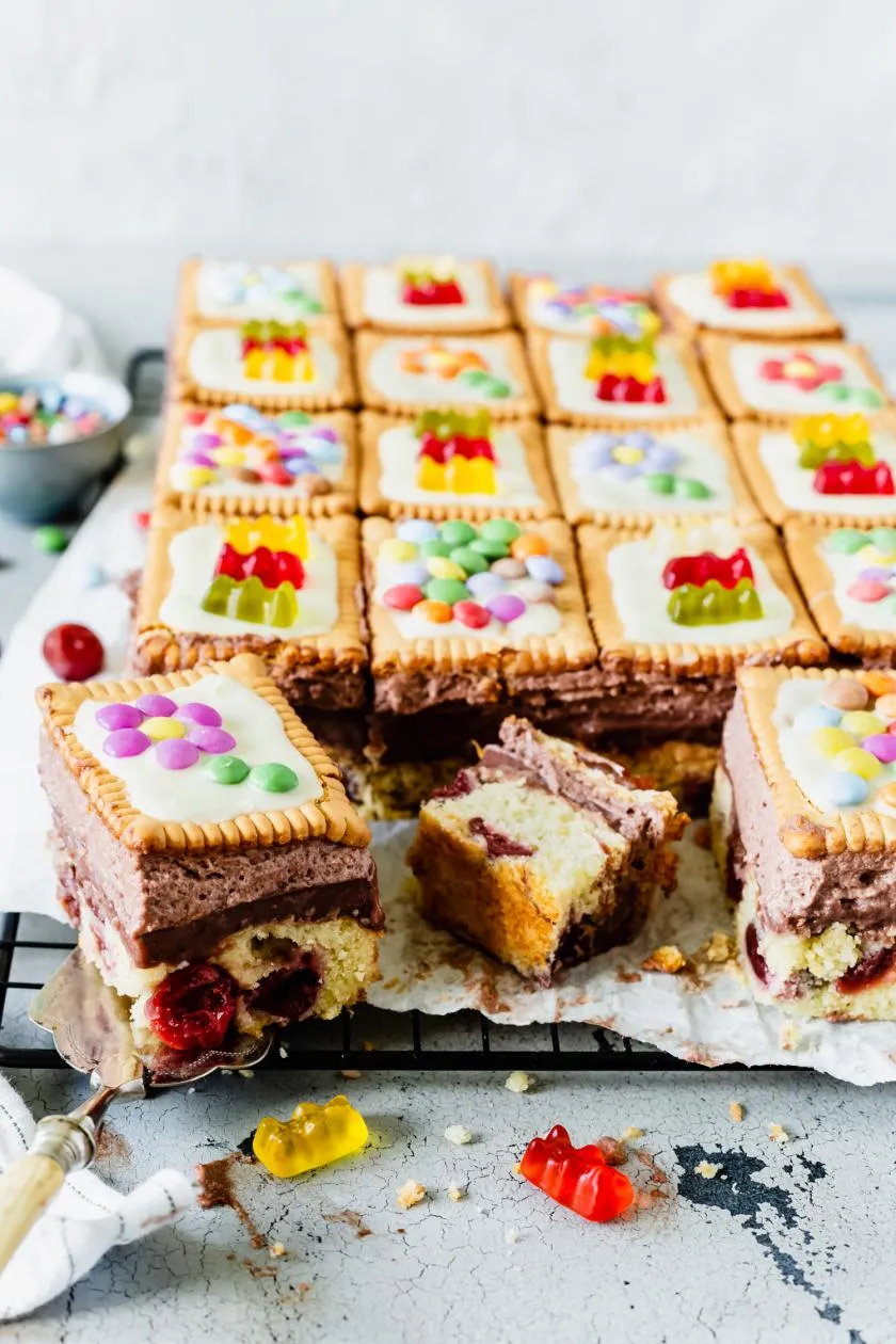 Bunter Fliesenkuchen mit Kirschen, Schokopudding und Gummibärchen, begeistert alle Kinder.
