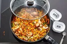 Buntes Gemüse in der Pfanne wird angedünstet, um seine Aromen zu entfalten