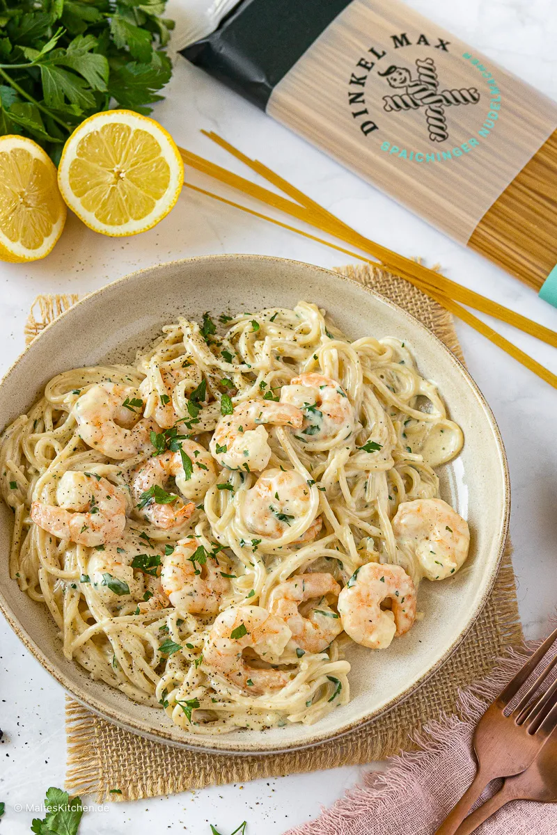 Cremige Spaghetti Alfredo mit knackigen Garnelen, fertig angerichtet auf einem Teller