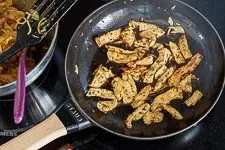 Das fertig gebratene Gyros-Fleisch wird aus der Pfanne genommen und warmgehalten