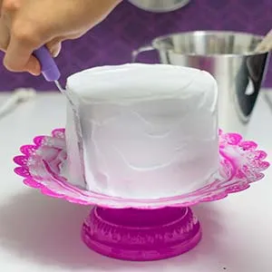 Der fertig mit veganer Sahne eingestrichene Regenbogen Geburtstagskuchen