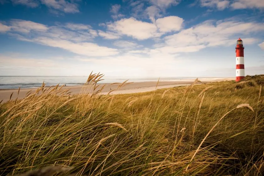 Der Leuchtturm von Amrum thront über dem breiten Sandstrand und der Nordsee.