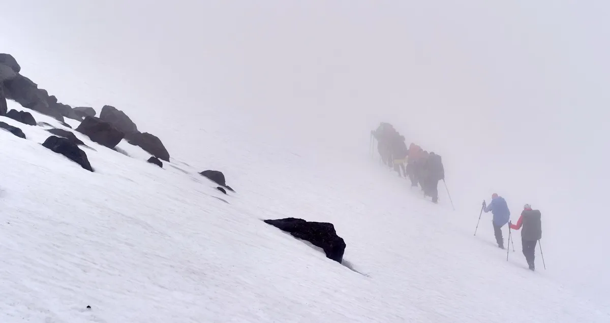 Dichter Nebel verhüllt die Sicht während des Aufstiegs auf einen Vulkan
