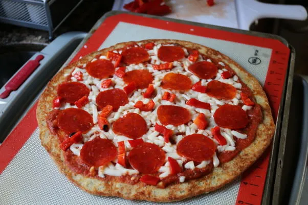 Die Low Carb Pizza mit Tomatensauce, Mozzarella und Peperoni belegt, bereit für den Ofen