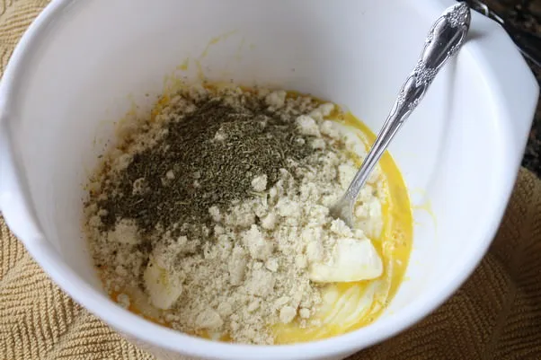 Die trockenen Zutaten werden zur Käsemischung hinzugefügt und vermengt