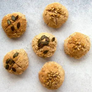 Drei frisch gebackene Buchweizenbrötchen auf einem Backblech, bereit zum Abkühlen