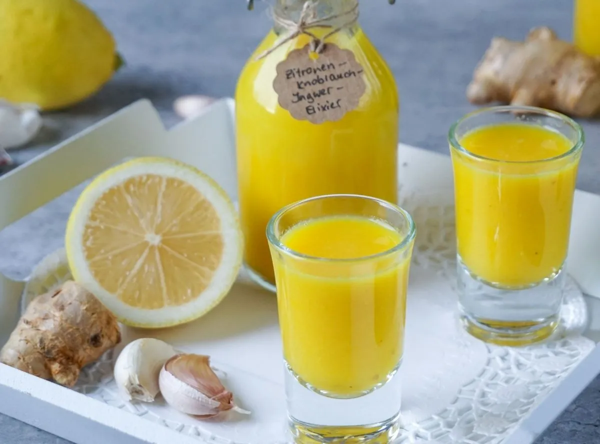 Drei gefüllte Eiswürfelbehälter mit Ingwer Shot, bereit zum Einfrieren