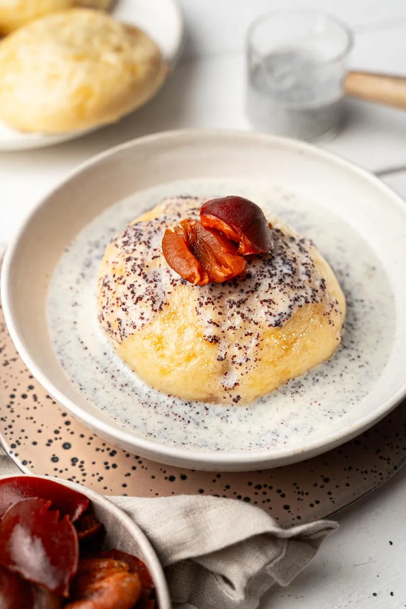 Drei Germknödel in einem Dampfgarer, bereit zum Servieren mit Mohn-Vanille-Soße