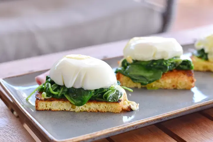 Ein einzelnes pochiertes Ei auf einem kleinen Teller.