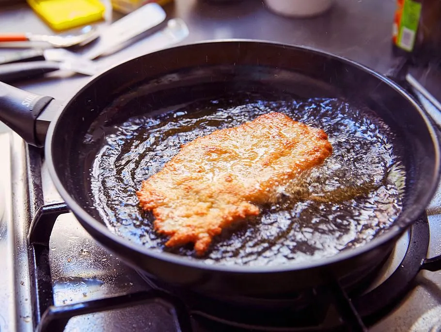 Ein fertig gebratenes Schnitzel, goldbraun und knusprig, appetitlich angerichtet mit Zitrone.