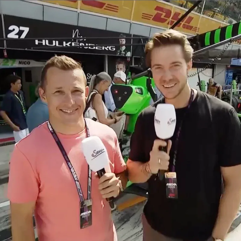 Ein Formel-1-Rennwagen fährt bei einem Grand Prix, während ein Mechaniker in der Boxengasse die Umgebung beobachtet.