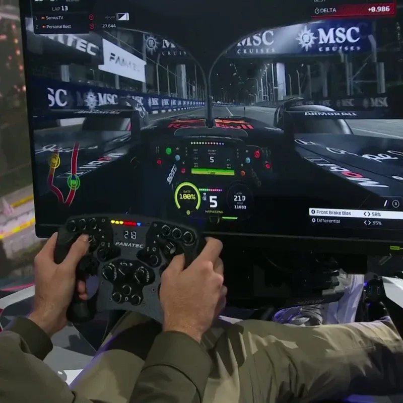 Ein Formel-1-Rennwagen rast mit hoher Geschwindigkeit über eine Rennstrecke, umgeben von Zuschauern und Tribünen.