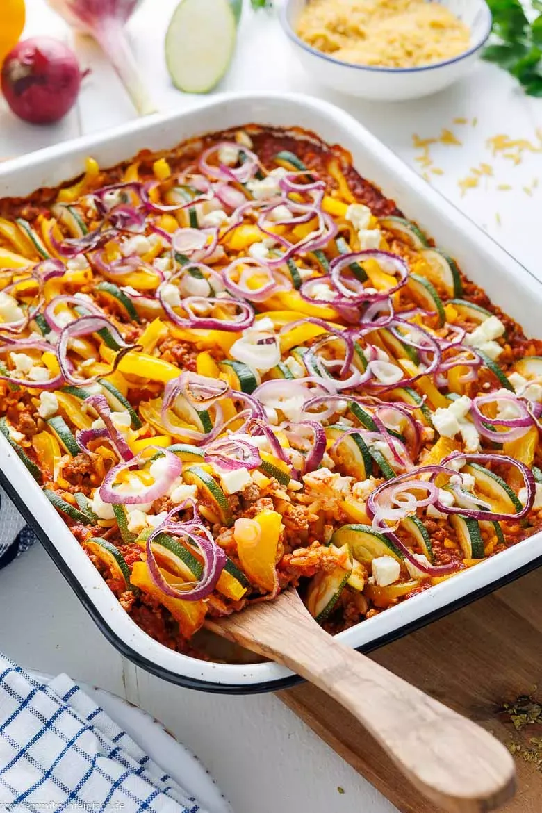 Ein frisch aus dem Ofen kommender griechischer Kritharaki-Auflauf mit Hackfleisch, Feta und bunten Gemüseschichten