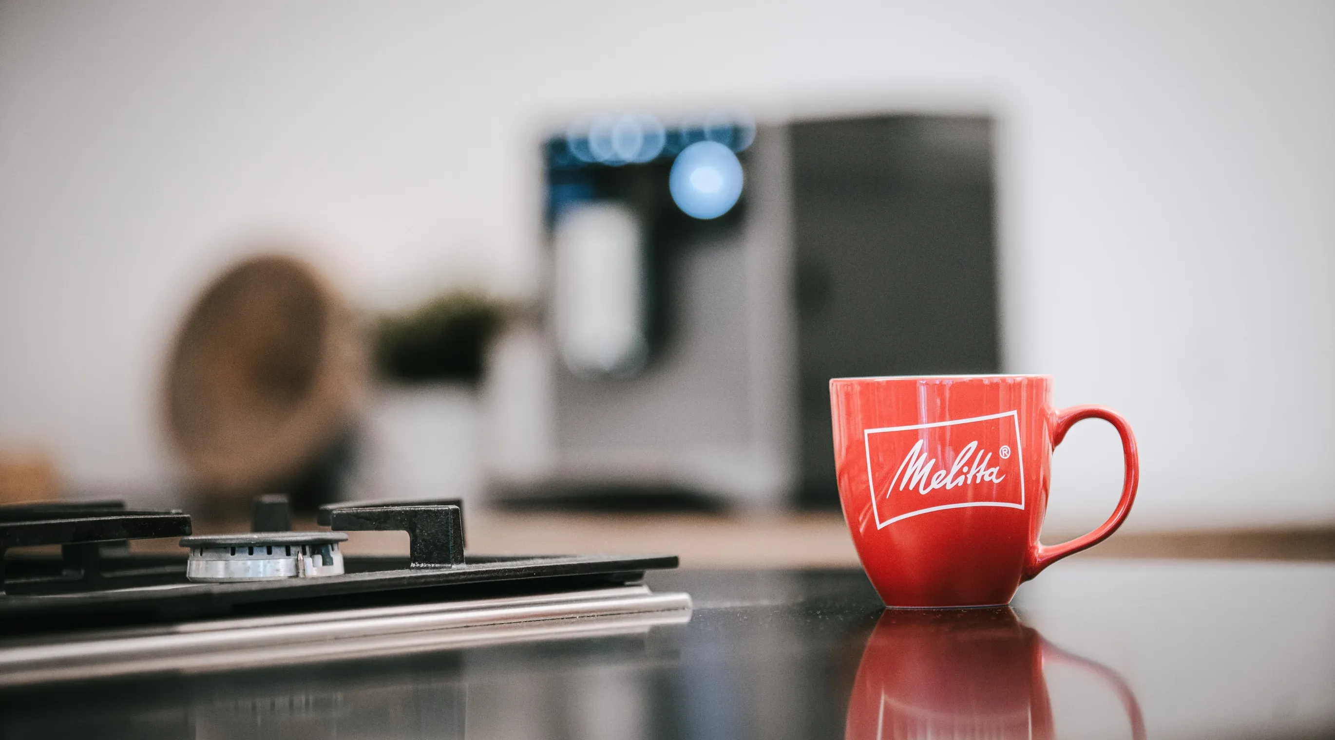 Ein Melitta CI Touch Plus Kaffeevollautomat in einer modernen Umgebung, Kaffeebohnen und eine Tasse daneben
