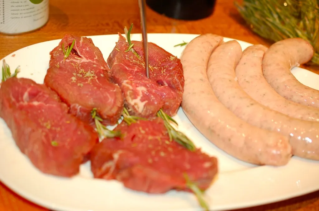 Ein Stück Fleisch, kunstvoll mit Rosmarin gespickt, bereit für die Zubereitung