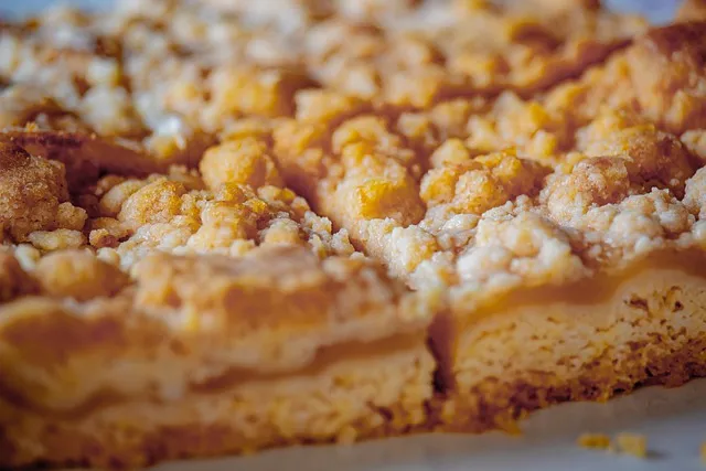Ein Stück Streuselkuchen von der Seite, das die knusprigen Streusel und den saftigen Teig zeigt