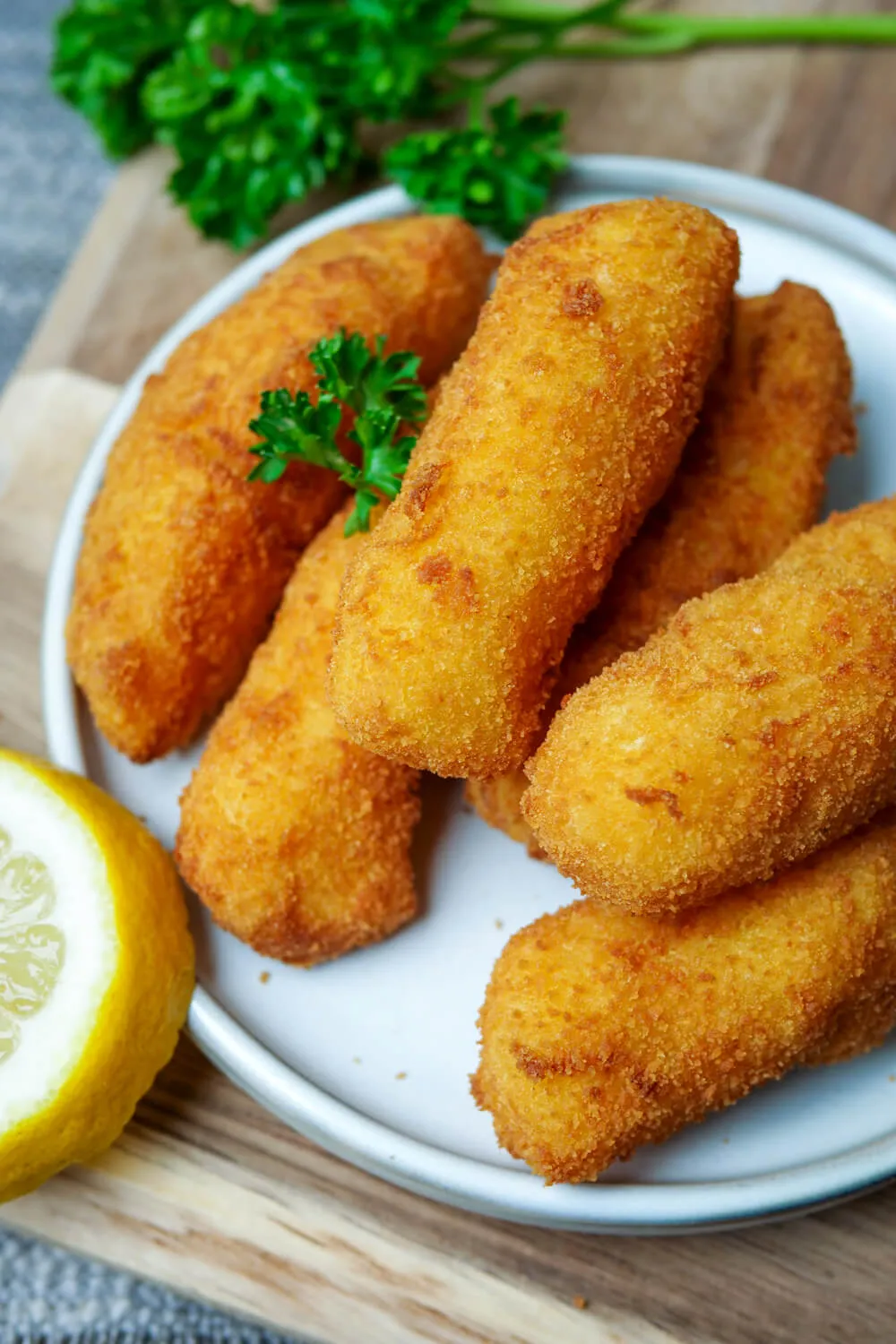 Ein Teller mit perfekt goldbraunen Kroketten, garniert mit frischer Petersilie.